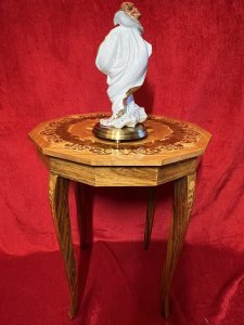 Italian Satinwood With Marquetry Floral Bouquet Inlaid Musical Table Circa -Vintage Composition - Satinwood With Exotic Wood Inlays Listing Description Fine Quality Italianate Marquetry Inlaid Musical Side Table With Dodecagon Shaped Top, Elaborately Adorned With Central Ornamental Bouquet Of Roses With Foliage & Meadow Flowers In An Array Of Exotic Wood. Large Bouquet Set Inside Walnut Shell Encased With Fine Amboyna Wood Scrollwork. Lift Up The Lid To Hear Musical Masterpiece Of Dr Zhivago And Reveal Storage Compartment For Books, Trinkets & Items Of Virtue. Top Set Upon Inlaid Sabre Legs Which To Allow Easy Movement And Packaging. Musical Winder On Underside And Makers Label Stamped Sorrento Italy. * No Original Key* *Pearls And Figurine Pictured Are Not Part Of Listing* Condition Excellent Used - Minor Scratches/ Marks Visible Due to Age And Usage. Dimensions In Inches Height 22.5" X Width 18.5" SQ For Further Information Please Call 07376 618513 Thank-you