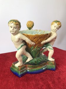 Italian Majolica Trio Of Cherubs Centrepiece With Green And Yellow Overglaze. Origin - Rome Italy. Circa - Vintage Trio Of Detailed Posed Cherubs Holding Delicate Flower Urn With Ornate Stepped Pedestal Base. Stunning Display Piece For Table Or Collection. Fine Replica Of 18th Century Grand-tour Piece. Heavy Glazed Pottery Beautiful Quality In Perfect Condition. Dimensions In Inches Height 11” Width 10.5” Circumference 29.5” Weight Approx 12 Kg