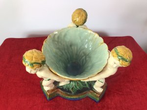 Italian Majolica Trio Of Cherubs Centrepiece With Green And Yellow Overglaze. Origin - Rome Italy. Circa - Vintage Trio Of Detailed Posed Cherubs Holding Delicate Flower Urn With Ornate Stepped Pedestal Base. Stunning Display Piece For Table Or Collection. Fine Replica Of 18th Century Grand-tour Piece. Heavy Glazed Pottery Beautiful Quality In Perfect Condition. Dimensions In Inches Height 11” Width 10.5” Circumference 29.5” Weight Approx 12 Kg