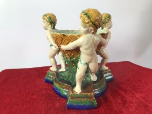 Italian Majolica Trio Of Cherubs Centrepiece With Green And Yellow Overglaze. Origin - Rome Italy. Circa - Vintage Trio Of Detailed Posed Cherubs Holding Delicate Flower Urn With Ornate Stepped Pedestal Base. Stunning Display Piece For Table Or Collection. Fine Replica Of 18th Century Grand-tour Piece. Heavy Glazed Pottery Beautiful Quality In Perfect Condition. Dimensions In Inches Height 11” Width 10.5” Circumference 29.5” Weight Approx 12 Kg