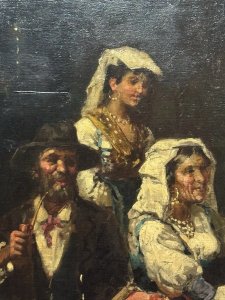 19th Century Spanish School Interior Folk Scene Manner Of José Gallegas Arnosa. Circa - 19th Century Composition - Oil On Canvas. This Fine Art Oil Painting Is A Spanish Folk Interior Scene From The Second Half Of The 19th Century, Depicting A Folkloric Genre With Four Figures Including Two Woman In Traditional Peasant Dress, A Gentleman Sitting Smoking A Pipe and Smartly Dressed Gentleman Ceremonial Military Attire.  The Group Sit At A Table Group Next To Roaring A Fire, Showcasing Traditional Attire And A Dramatic, Warm Colour Palette. It Is Attributed To The Andalusian Painter José Gallegos y Arnosa (1857-1917), Known For His Attention To Detail And Scenes Of Daily Life. Dimensions In Cms Height 83cm xx Width 67cm
