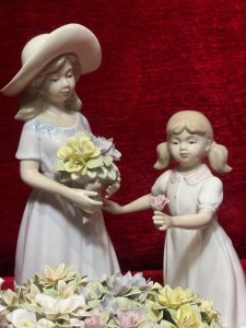 The Flower Harvest Porcelain Figurine By The Leonardo Collection Circa - Vintage Condition - Pristine Composition - Porcelain Listing Description Wonderfully Elegant Large Leonardo Collection Figurine Totle ‘The Flower Harvest’ Depicting A Mother And Daughter Picking Flowers From Decorative Flower Kart. Stamped On Base. Dimensions In Cms Height 26cm X Width22cm X Depth 22cm