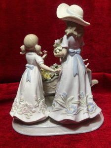 The Flower Harvest Porcelain Figurine By The Leonardo Collection Circa - Vintage Condition - Pristine Composition - Porcelain Listing Description Wonderfully Elegant Large Leonardo Collection Figurine Totle ‘The Flower Harvest’ Depicting A Mother And Daughter Picking Flowers From Decorative Flower Kart. Stamped On Base. Dimensions In Cms Height 26cm X Width22cm X Depth 22cm
