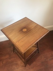 Antique Edwardian Fine Satinwood Centre Table With Herringbone Inlays And Centre Motif Circle Of Satinwood With Inlaid Stringing On Tapered Legs With Bottom Gallery Shelf For Display In Good Condition With Some Very Slight Fine Marks Conductive To Age And Usage Dimensions In Inches Height 27” Top 19” Square Bottom Gallery Shelf 13” Square