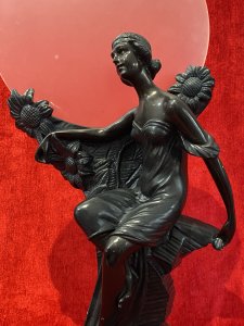 Art Nouveau Figurative Sculpture Of Young Female & Sunflowers With Frosted Sphere Backdrop Circa - 1910 Composition - Chalk Ware Colour - Bronze Effect Listing Description Iconic French Sculptural Masterpiece After Louis Beatuax, Titled - Jeune Femme Aux Tournesols ( Young Woman With Sunflowers) Depicting Posed Art Nouveau Lady Sat Upon Textural Rock Mound Decorated With Large Sunflowers. Circular Frosted Plate Sits In Indentation Behind Sculpture. Condition - Very Good Showing Genuine AGE, Signs Of Minor Knocks & Scratches , Chalk Ware Can Be Seen In Parts. Minor Signs Of Mismatched Paintwork Were Paint Has Be Previously Touched In. Glass Sphere Has Minor Scuffs/ Marks Due To Age. This Does Not Detract From Beauty Of The Sculpture. Dimensions In Cms Overall Height 37Cm Frosted Plate Diam 24.5Cm Sculpture Width 23Cm Sculpture Depth 11Cm