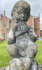 Water Feature Centrepiece Of Faun Boy Sat Upon Scalloped Bowl. Circa - 20th Century Composition- Reconstituted Stone Condition- Weathered Used Pristine Decorative Water Feature Of Scalloped Bowl Set Upon Square Oval Plinth Pediment With Bow And Column Pillared Decoration, With Central Sitting Faun Playing Mouth Organ With Hoove Feet And Bushy Tail. A Hole For Water Hose Through Base Pediment Into Scalloped Bowl. A True Mythological Piece An Asset To Any Garden Decor. Dimensions In Inches Height 30” Width 19” Depth 18” Weight Approx 30Kg Heavy Item