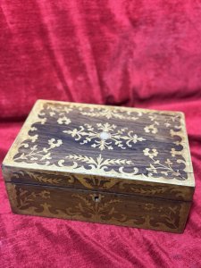 Antique Marquetry Inlaid Rosewood Jewellery/Sewing Casket Box C.1900 Circa - 1860 Composition - Rosewood Case Satinwood Inlay. Listing Description Beautiful Rosewood Sewing/Jewellery Casket With Fine Quality Floral Inlays On The Top And Front Elevations Of The Box. The Lid Of The Box Decorated With Leaves And Ornate Floral Sprays. In The Centre A Intricate Cartouche. The Front Of The Box Also With Rose Cartouche Around The Lock And Floral Sprays Surrounding. Exceptional Handcrafted Inlays In Satinwood. The Box Interior Has A Satin Covered Lift Out Compartmental Shelf, Which RevealsThe Casket Base With Extra Storage. Lovely Original Condition/ No Key Many Uses For Jewellery/ Charms/ Trinkets/ Sewing/ Crafting/ Keys/ Any Luxury Storage. Dimensions In Inches Height 4 1/4” X Width 11” X Depth 7 1/4”