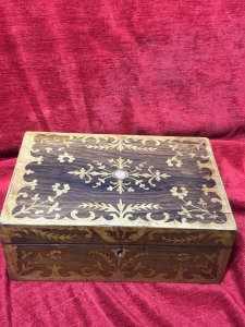 Antique Marquetry Inlaid Rosewood Jewellery/Sewing Casket Box C.1900 Circa - 1860 Composition - Rosewood Case Satinwood Inlay. Listing Description Beautiful Rosewood Sewing/Jewellery Casket With Fine Quality Floral Inlays On The Top And Front Elevations Of The Box. The Lid Of The Box Decorated With Leaves And Ornate Floral Sprays. In The Centre A Intricate Cartouche. The Front Of The Box Also With Rose Cartouche Around The Lock And Floral Sprays Surrounding. Exceptional Handcrafted Inlays In Satinwood. The Box Interior Has A Satin Covered Lift Out Compartmental Shelf, Which RevealsThe Casket Base With Extra Storage. Lovely Original Condition/ No Key Many Uses For Jewellery/ Charms/ Trinkets/ Sewing/ Crafting/ Keys/ Any Luxury Storage. Dimensions In Inches Height 4 1/4” X Width 11” X Depth 7 1/4”