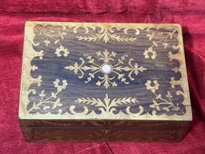 Antique Marquetry Inlaid Rosewood Jewellery/Sewing Casket Box C.1900 Circa - 1860 Composition - Rosewood Case Satinwood Inlay. Listing Description Beautiful Rosewood Sewing/Jewellery Casket With Fine Quality Floral Inlays On The Top And Front Elevations Of The Box. The Lid Of The Box Decorated With Leaves And Ornate Floral Sprays. In The Centre A Intricate Cartouche. The Front Of The Box Also With Rose Cartouche Around The Lock And Floral Sprays Surrounding. Exceptional Handcrafted Inlays In Satinwood. The Box Interior Has A Satin Covered Lift Out Compartmental Shelf, Which RevealsThe Casket Base With Extra Storage. Lovely Original Condition/ No Key Many Uses For Jewellery/ Charms/ Trinkets/ Sewing/ Crafting/ Keys/ Any Luxury Storage. Dimensions In Inches Height 4 1/4” X Width 11” X Depth 7 1/4”