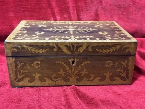 Antique Marquetry Inlaid Rosewood Jewellery/Sewing Casket Box C.1900 Circa - 1860 Composition - Rosewood Case Satinwood Inlay. Listing Description Beautiful Rosewood Sewing/Jewellery Casket With Fine Quality Floral Inlays On The Top And Front Elevations Of The Box. The Lid Of The Box Decorated With Leaves And Ornate Floral Sprays. In The Centre A Intricate Cartouche. The Front Of The Box Also With Rose Cartouche Around The Lock And Floral Sprays Surrounding. Exceptional Handcrafted Inlays In Satinwood. The Box Interior Has A Satin Covered Lift Out Compartmental Shelf, Which RevealsThe Casket Base With Extra Storage. Lovely Original Condition/ No Key Many Uses For Jewellery/ Charms/ Trinkets/ Sewing/ Crafting/ Keys/ Any Luxury Storage. Dimensions In Inches Height 4 1/4” X Width 11” X Depth 7 1/4”