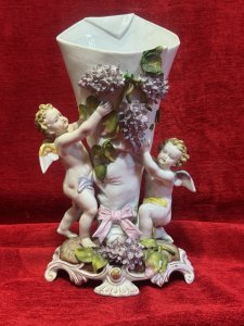 Antique Dresden Porcelain Cherub & Wisteria Decorative Vase Circa - 19th Century Composition - Porcelain Listing Description Rare 19th Century Wisteria And Winged Cherub Ornamental Vase. Fine Detail With Hand Sculpted Cherubs Holding Up Cornucopia Shaped Flower Urn Decorated With Wisteria Vines. Dresden Foundry Mark On Base. Dimensions In Cms Height 28cm X Width 18cm at Base Mouth Opening 12cm x 10cm