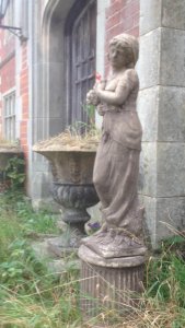 Wheat Maiden Statue In The Regency Style Upon A Round Corinthian Plinth. Elegant Lady Holding A Shelf Of Wheat Stunning Tall Statue Stand Upon A Round Fluted Corinthian Plinth Reconstituted Stone Purchased From Manor House In Lisguard Cornwall Weight Approx 60kg Lifts Off Plinth Dimensions In Inches Total Height 52 1/4” Statue Height 39” Width 12” Depth 8.5” Circular Plinth Base Height 13 1/4” Width 11”