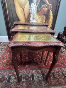 Regency Queen Anne Style Nest of Three Tables In Rich Mahogany With Green Tooled Leather Glazed Tops Circa - 1950 Composition - Mahogany Wood/ Leather/ Glass Listing Description Original Vintage Ornately Carved Acanthus Pattern Solid Mahogany Nesting Tables With Elegant Queen Anne Legs. Tooled Green Leather And Glass Protective Glazed Tops. Dimensions In Inches Large Table Height 22" X Width22 3/4" X Depth 17" Small Table Height 19 3/4" X Width 14.5" X Depth 12" For Further Information Please Call The museum Curator On 07707 488566 Thankyou.