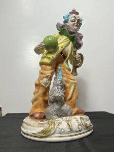 Magnificent Large Capodimonte Bright Glazed Circus Clown Figurine With Dog Companion. Circa - Vintage Composition - Glazed Porcelain Listing Description Large Stylised Hand Painted Circus Clown With Bold Face Paint, Blue Tufted Hair And Pointed Pink Hat. Oversized Double Flounced Neck Ruff Over Vibrant Yellow Spotted Coat. Orange Baggy Trouser With Comical Teared Hole At The Knee. This Magnificent Clown Holds Green Ball And Bugle Horn. A Fellow Dog Companion Sits Poised Upon The Circular Base With Blue Collar And Matching Hat. Wonderful Rare Piece For Collector Of Clowns \ Capodimonte And Circus Memorabilia. Condition - Used Sadly The Top Of The Bugal Has Been Damaged Please See Images. A Few Small Chips To Paint Visible Due To Age And Usage. This Does Not Detract From The Beauty Of The Piece But Is Reflective In The Price. Dimensions In Inches Height 20" Width 9" Depth 10"