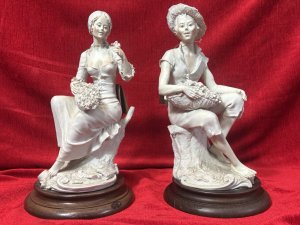Pair Of Traditional Italianate Sitting Male/Female Capodimonte Style Figurines On Wood Plinths Circa - 1980 Composition - Porcelain on Wood Plinth Listing Description Wonderful Perfect Pair Of Italian Capodimonte Style Figurines. Female Sitting On Tree Stump With Floral Basket, Holds Rose In left Hand. Male Seated On Tree Stump Wears Straw Hat Holding Fruit Basket. Both Signed On Base By Artist A Berni And ADT ITALY With Capodimonte Style Ink Mark. Set Upon Polish Wood Base Plinths. Dimensions In Cms Male Height 32cm X Width 16cm X Depth 20cm X Base Diam 18cm Female Height 31.5cm X Width 16cm X Depth 14cm x Base Diam 18cm