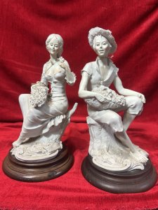 Pair Of Traditional Italianate Sitting Male/Female Capodimonte Style Figurines On Wood Plinths Circa - 1980 Composition - Porcelain on Wood Plinth Listing Description Wonderful Perfect Pair Of Italian Capodimonte Style Figurines. Female Sitting On Tree Stump With Floral Basket, Holds Rose In left Hand. Male Seated On Tree Stump Wears Straw Hat Holding Fruit Basket. Both Signed On Base By Artist A Berni And ADT ITALY With Capodimonte Style Ink Mark. Set Upon Polish Wood Base Plinths. Dimensions In Cms Male Height 32cm X Width 16cm X Depth 20cm X Base Diam 18cm Female Height 31.5cm X Width 16cm X Depth 14cm x Base Diam 18cm