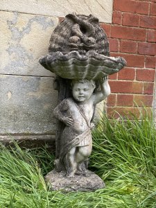 Classical Cherub Holding Scallop Shell Basin With Dolphins Bird Bath. Circa - Vintage Composition- Reconstituted Stone Condition- Used Original Weathered Beautifully Detailed Cherub Stands Against Scrolled Column Carefully Balancing A Scallop Shell Basin Above His Head With Ornamental Dolphins Fountain Design. Refined Facial Features With Eloquent Hands. An Exceptional Vintage Piece Inspired By French 18th Century Architecture. Stunning Garden Feature For Attracting Birds And Wildlife. Heavy Item. Provenance Purchased From 18th Century Stately Home Walled Market Garden, Derby. Dimensions In Cms Height 86cm Width 42cm Depth 29cm