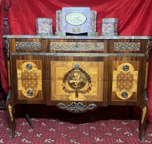 French Régency Ormolu Mounted & Marquetry Inlaid Breakfront Marble Top Commode Circa - 1980 Composition - Sold Wood Frame With Precious Wood Inlay/ Marble Top Listing Description Impeccable Fine Quality French Régence Style Break Front Commode, With Canted Corners And An Abundance Of Ormolu Mounts. Solid Carrera Marble Top With Rich Grain Work. Front Face Comprised Of Richly Decorated Ormolu Top Mount Over Two Drawers Adorned With Elaborate Precious Wood Inlays To Include, Rose Wood, Satin Wood, Amboyna Wood And Fruit Wood. A Showpiece Of Central Cameo, Inside A Winged Putti Playing Loot, Encased By A Elegant Wheat Sheaf Frame, Held By Ribbon Inside Geometric Boarder. Either Side A Symbolic Masterpiece Of Parquetry Themed Motifs. Both Drawers Complete With Brass Ormolu Garland Drop Handles. Matching Side Elevations With Delicate Floral Motifs Inlays And Mounts. Cabinet Set Upon Splayed Legs. Dimensions In Inches Height 31.5" X Width 43" X Depth 18.5" Provenance Purchased From Parisian Chateau Private Collector. Heavy/Fragile Item Requires Hand Delivery. For Any Further Information Please Call The Curator On 07707 488566 Thank-you.