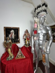 Mesmerising Collection Of Native American ' Big Chief Sitting Bull' Memorabilia Circa - Vintage Composition - Mixed Materials *Head Dress - Calf Skin, Axe Figure - Resin, Bow & Arrows - Wood Mixed Media, Tipi - Wood & Resin Figures, Paintin - Velvet Canvas Wood Frame.* Listing Description Thought Provoking Collection Of Native American Big Chief Sitting Bull Memorabilia. Six Piece Set Includes Warbonnet Head Dress In Calf Skin With Decorative Beaded Edge, Animal Pelts And Large Plumes Of Feathers. Indian Chief Painting On Velvet Set In Ornate Carved Wood Frame. A Decorative String Bow With Carved Wood Chief Handle And String Line, Matching Decorated Cylindrical Holster With Wood Arrows (Bow And Arrows For Decoration Only). An Interesting Wooden Tipi Sculpture With Internal Sitting Chief And Squaw With Holster Of Arrows, A Charming Peeping Hole In The Back Of Tipi Gives it Great Interest. Large Native Indian Figure With Axe In Tradition Native Clothing. * Native Indian With Bow Figurine not Included With Set * Wonderful Set For Collector Of Tribal Memorabilia Or Use As Props. Provenance Purchased From Avid Collector Of Chief Sitting Bull Memorabilia, And Now Part Of Private Lord Hill Museum Collectoion. Dimensions in Inches Painting Height 22 3/4 X Width 18 3/4 Tipi Height Height 13 1\4 X Width 10.5" X Depth 5 1/4 Axe Figure Height 24" X Width 12" X Depth 14" Bow Height 53" X Width 8" X Depth 2" Arrows Height 26" X Width 8" x Depth 2" Warbonnet Head Dress Height 31" X Width 23" X Depth 16"