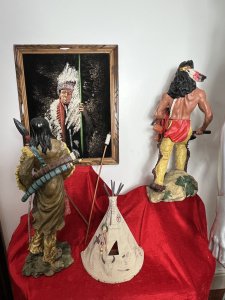 Mesmerising Collection Of Native American ' Big Chief Sitting Bull' Memorabilia Circa - Vintage Composition - Mixed Materials *Head Dress - Calf Skin, Axe Figure - Resin, Bow & Arrows - Wood Mixed Media, Tipi - Wood & Resin Figures, Paintin - Velvet Canvas Wood Frame.* Listing Description Thought Provoking Collection Of Native American Big Chief Sitting Bull Memorabilia. Six Piece Set Includes Warbonnet Head Dress In Calf Skin With Decorative Beaded Edge, Animal Pelts And Large Plumes Of Feathers. Indian Chief Painting On Velvet Set In Ornate Carved Wood Frame. A Decorative String Bow With Carved Wood Chief Handle And String Line, Matching Decorated Cylindrical Holster With Wood Arrows (Bow And Arrows For Decoration Only). An Interesting Wooden Tipi Sculpture With Internal Sitting Chief And Squaw With Holster Of Arrows, A Charming Peeping Hole In The Back Of Tipi Gives it Great Interest. Large Native Indian Figure With Axe In Tradition Native Clothing. * Native Indian With Bow Figurine not Included With Set * Wonderful Set For Collector Of Tribal Memorabilia Or Use As Props. Provenance Purchased From Avid Collector Of Chief Sitting Bull Memorabilia, And Now Part Of Private Lord Hill Museum Collectoion. Dimensions in Inches Painting Height 22 3/4 X Width 18 3/4 Tipi Height Height 13 1\4 X Width 10.5" X Depth 5 1/4 Axe Figure Height 24" X Width 12" X Depth 14" Bow Height 53" X Width 8" X Depth 2" Arrows Height 26" X Width 8" x Depth 2" Warbonnet Head Dress Height 31" X Width 23" X Depth 16"