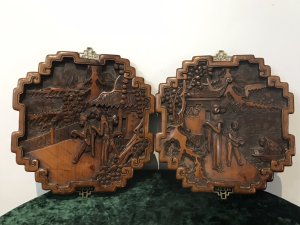 Fine Quality Pair Of Oriental Minh Dynasty Style Hardwood Decorative Wall Plaques Kang Si Style Intricately Carved With Figures In Landscape Stunning Shaped Frames With Ornate Brass Hanging Brackets Circa - 1920’s Origin - Chinese Dimensions In Inches Height 13” Width 11.5” Depth 3/4”