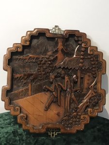 Fine Quality Pair Of Oriental Minh Dynasty Style Hardwood Decorative Wall Plaques Kang Si Style Intricately Carved With Figures In Landscape Stunning Shaped Frames With Ornate Brass Hanging Brackets Circa - 1920’s Origin - Chinese Dimensions In Inches Height 13” Width 11.5” Depth 3/4”
