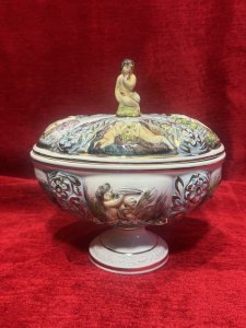 Capodimonte Ornamental Putti & Floral Spray Lidded Vase Maker - Stamped Capodimonte Composition - Porcelain Listing Description Capodimonte Porcelain Lidded Jardiniere Vase. All Sides Depicting Detailed Relief Scenes Of Cherub Figures With Shells Near The Waters Edge Surrounded By Floral Sprays, Vibrant Colour Palette With Excessive Gilt Work. Maker Stamp Capodimonte Numbered 238 On Base. Pristine Condition. Dimensions In Cms Height 21.5cm x Width 22cm X Depth 16cm