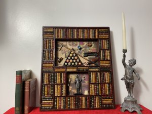 Decorative American Pool Library Setting Diorama Wall Display Collectors Piece. Rudolf Walter Wonderone Style Wonderfully Detailed American Pool Themed Diorama Display With Refrence Library Books Shelf Surround In Mahogany Frame. Central Top Shelf Displays American Pool Balls Set In Triangle, Resting Pool Que , Chalk, Wax And Que Rest On Decorative Pool Players Paper Cutting Montage Background. Bottom Shelf With American Pool Champion Trophy With Pool Player Pictures Montage Background. Craftsman Made Piece In Solid Carved Wood. Metal Hanging Hooks For Wall Hanging On Reverse. Exceptional Piece For Gentleman’s Room/ Man Cave Display. Highly Decorative Rare Reproduction Piece In Stunning Condition. Dimensions In Inches Height 21 3/4” Width 18.5” Depth 1 1/4”