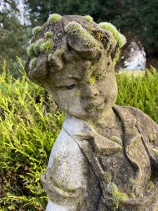 Country Estate Gardening Boy Holding Straw Bower Garden Sculpture. Composition- Reconstituted Stone Circa - Vintage Charming Young Gardening Boy With Handsome Face And Curled Hair Wears Collared Shirt, Dungarees And Lace Up Boots. Holding Straw Bower In His Hand. Beautiful Weathered Garden Centre Piece With Organic Foliage and Moss Clumps Organically Growing On The Statue. This Really Adds To The Charm Of The Piece. Beautiful Sculpture For Country Garden, Rockeries , Patio. Provenance Purchased From Scottish Country Manor And Now Part Of Historical Lord Hill Museum Private Collection. Dimensions In Inches Height 28” Width 12 Base Width 10 X Depth 9
