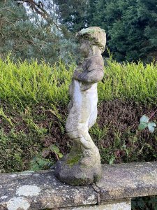 Country Estate Gardening Boy Holding Straw Bower Garden Sculpture. Composition- Reconstituted Stone Circa - Vintage Charming Young Gardening Boy With Handsome Face And Curled Hair Wears Collared Shirt, Dungarees And Lace Up Boots. Holding Straw Bower In His Hand. Beautiful Weathered Garden Centre Piece With Organic Foliage and Moss Clumps Organically Growing On The Statue. This Really Adds To The Charm Of The Piece. Beautiful Sculpture For Country Garden, Rockeries , Patio. Provenance Purchased From Scottish Country Manor And Now Part Of Historical Lord Hill Museum Private Collection. Dimensions In Inches Height 28” Width 12 Base Width 10 X Depth 9