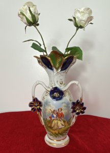 Sevres Style Romantic Porcelain Vase With Branch Handles And Flora Decorations. Circa ~1880 Leaf Adorned Vase Top In Asymmetric Pattern Heavily Gilt With Green And Blue Coloration. Heart Shaped Branch Like Handles With Three Floral Plaque Decorations. Central Romantic Panel Of Loving Couple In 18Th Century Clothing Reclining In Delicate Shadowed Landscape. Delicate Pastel Hues Complemented With Vibrant Green And Royal Blue. Makers Mark No 71 P&A Embossed On Base. Condition- Antique Used Perfect Condition No Damage. Wear To Gilt Work Decoration Conducive To Age And Usage. Dimensions In Inches Height 12” Width 7”