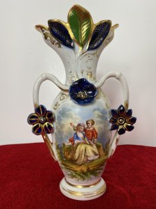 Sevres Style Romantic Porcelain Vase With Branch Handles And Flora Decorations. Circa ~1880 Leaf Adorned Vase Top In Asymmetric Pattern Heavily Gilt With Green And Blue Coloration. Heart Shaped Branch Like Handles With Three Floral Plaque Decorations. Central Romantic Panel Of Loving Couple In 18Th Century Clothing Reclining In Delicate Shadowed Landscape. Delicate Pastel Hues Complemented With Vibrant Green And Royal Blue. Makers Mark No 71 P&A Embossed On Base. Condition- Antique Used Perfect Condition No Damage. Wear To Gilt Work Decoration Conducive To Age And Usage. Dimensions In Inches Height 12” Width 7”
