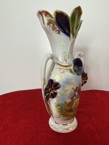 Sevres Style Romantic Porcelain Vase With Branch Handles And Flora Decorations. Circa ~1880 Leaf Adorned Vase Top In Asymmetric Pattern Heavily Gilt With Green And Blue Coloration. Heart Shaped Branch Like Handles With Three Floral Plaque Decorations. Central Romantic Panel Of Loving Couple In 18Th Century Clothing Reclining In Delicate Shadowed Landscape. Delicate Pastel Hues Complemented With Vibrant Green And Royal Blue. Makers Mark No 71 P&A Embossed On Base. Condition- Antique Used Perfect Condition No Damage. Wear To Gilt Work Decoration Conducive To Age And Usage. Dimensions In Inches Height 12” Width 7”