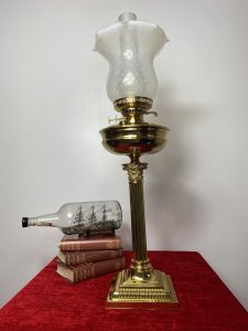 Brass Corinthian Column Table Oil Lamp With White Opaque Glass Funnel & Shade. Beautiful Decorative Brass Corinthian Table Lamp Stand With Oil Lamp Top And Rare Opaque Bristol Glass Funnel And Bell Shaped Shade. Beautifully Restored With Oil Vessel Tank And Wick In Exceptional Condition. Perfect Working Order. Handsome Design Made Originally In Pall Mall London By Quality Manufacturer. Dimensions In Inches Height 29” Base Width Square 6 3/4” Weight Approx 15KG