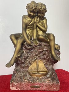 French Art Nouveau Gilt Children Upon Rock With Sailboat Rouge Marbled Sculpture Circa - 1920's Composition - Over Glazed Earthenware Large Museum Quality Sculpture Depicting Two Young Boys Perched Together Upon A Red Dripglaze Marbled Rock. Both Looking Down At Toy Sailboat In The Water. Fine Detail Of Cherabesent Childern With Defined Smiling Faces, Detailed Hands And Feet. Wonderful Artwork Captures The Mood & Movement In The Clothing And Water. Beautiful Quality & Charming Subject Displaying Brass Title Plaque Reading FUTURS MARINS. Condition - Original Antique Used Showing Signs Of Wear Conducive To Age. Provenance Purchased From Paris Collector Dimensions In Inches Height 19" Width 13" Base 10" X 7"