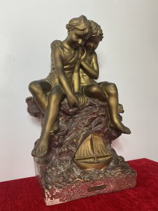 French Art Nouveau Gilt Children Upon Rock With Sailboat Rouge Marbled Sculpture Circa - 1920's Composition - Over Glazed Earthenware Large Museum Quality Sculpture Depicting Two Young Boys Perched Together Upon A Red Dripglaze Marbled Rock. Both Looking Down At Toy Sailboat In The Water. Fine Detail Of Cherabesent Childern With Defined Smiling Faces, Detailed Hands And Feet. Wonderful Artwork Captures The Mood & Movement In The Clothing And Water. Beautiful Quality & Charming Subject Displaying Brass Title Plaque Reading FUTURS MARINS. Condition - Original Antique Used Showing Signs Of Wear Conducive To Age. Provenance Purchased From Paris Collector Dimensions In Inches Height 19" Width 13" Base 10" X 7"