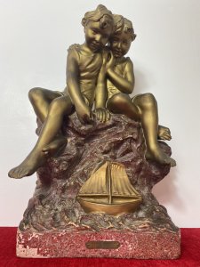 French Art Nouveau Gilt Children Upon Rock With Sailboat Rouge Marbled Sculpture Circa - 1920's Composition - Over Glazed Earthenware Large Museum Quality Sculpture Depicting Two Young Boys Perched Together Upon A Red Dripglaze Marbled Rock. Both Looking Down At Toy Sailboat In The Water. Fine Detail Of Cherabesent Childern With Defined Smiling Faces, Detailed Hands And Feet. Wonderful Artwork Captures The Mood & Movement In The Clothing And Water. Beautiful Quality & Charming Subject Displaying Brass Title Plaque Reading FUTURS MARINS. Condition - Original Antique Used Showing Signs Of Wear Conducive To Age. Provenance Purchased From Paris Collector Dimensions In Inches Height 19" Width 13" Base 10" X 7"