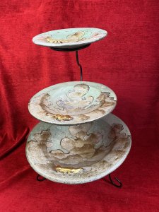 Vintage Mesa Verde Style Hand Painted 3 Tier Fruit Stand With Lizard Motifs. Circa - Vintage Composition- Earthenware / Pottery Colour Way - Blue, Teal, Gold Stunning Three Tier Metal Stand With Elegant Tripod Legs. Complete With Three Diminishing Bowls Hand Painted With Abstract Canyon Style Landscape With Ornate Gilt Lizard Motif On Each Bowl Edge. Exceptionally Decorative Piece For Fruit / Bon Bons Or Floral Display. Strong Mesa Verde National Park Tribal Influence. Dimensions In Inches Height 22” Top Bowl Diam 8” Medium Bowl Diam 11.5” Bottom Bowl 15 3/4”