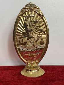 50 Year Commemorative Gold Plated Plaque Celebrating Second World War D Day Circa - 1994 Composition - Gold Plated Metal Elaborate Oval Gold Plated Plaque On Stand To Commemorate The Largest Sea Borne Invasion In History Embossed With Sea View With British Isles Outline, War Planes, Soldiers Parachuting And Fighter Bombers/Ships With Large Tank. Showing All Landmarks Of The War And Encrusted With Semi Precious Stones. Winston Churchill Quote In Tribute To The Bomber And Air Crews For They're Enormous Efforts To Establish Air Superiority Over England. ' NEVER IN THE FIELD OF HUMAN CONFLICT WAS SO MUCH OWED BY SO MANY TO SO FEW' Stamped On The Back Sterling Mint London. Provenance Purchased Directly From War Veteran, London. Dimensions In Inches Height 8" Base 3" Diameter