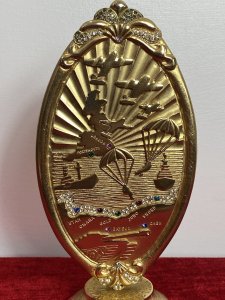 50 Year Commemorative Gold Plated Plaque Celebrating Second World War D Day Circa - 1994 Composition - Gold Plated Metal Elaborate Oval Gold Plated Plaque On Stand To Commemorate The Largest Sea Borne Invasion In History Embossed With Sea View With British Isles Outline, War Planes, Soldiers Parachuting And Fighter Bombers/Ships With Large Tank. Showing All Landmarks Of The War And Encrusted With Semi Precious Stones. Winston Churchill Quote In Tribute To The Bomber And Air Crews For They're Enormous Efforts To Establish Air Superiority Over England. ' NEVER IN THE FIELD OF HUMAN CONFLICT WAS SO MUCH OWED BY SO MANY TO SO FEW' Stamped On The Back Sterling Mint London. Provenance Purchased Directly From War Veteran, London. Dimensions In Inches Height 8" Base 3" Diameter