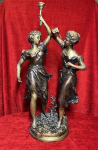 Ernest Rancoulet Bronze Sculpture Of Two Ladies Lighting Torcher Titled 'Olympia' Circa - 1890 Composition - Bronze Origin - France Brief History Of Sculptor Ernest Rancoulet 1870-1915 Prolific French Sculptor Renowned For Figurative Neoclassical Sculpture With Mythological Themes And Allegory. Ernest Rancoulet's Sculptures Are Highly Prized For Their Realism, Grace And Intricate Detailing, Many Of His Sculptures Were Produced As Limited Editions, Some Created In Pairs Usually Of The Same Individual In Different Poses Viewed From Alternate Angles. Rancoulet Resided In The French Salon For Many Years Exhibiting His Works Of Figurines & Portrait Busts, Often Casting Two Varying Copies Of The Same Subject To Be Displayed In Pairs. This Noitoriety And Fine Craftsmanship Of His Work Is Highly Sort After Today. Listing Description. Sculpture Title ; 'Olympia' Wonderful Fine Quality Bronze Figural Sculpture After Ernest Rancoulet, Depicting The Goddess 'Olympia' In Two Poses. The Left Female Gazes To The Right Holding A Torcher In Her Left Hand Above Her Head, The Right Figure Gazes To The Left Holding A Wick In Her Right Hand At Eye Line. Both Figures Styled Gracefully With Hair Set Off The Face, Delicate Facial Features,Wearing The Same Elaborate Gown. Both Figures Set Upon Oval Plinth Of Sprawling Foliage With Tree Sprig. Stunning Original Patina With Vivid Gold Tones. Dimensions In Inches Height 20 1/4" Width 11.5" Base 7" X 7" Provenance Purchased From Parisian Gallery. Now Part Of Lord Hill Museum Private Collection For Further information Please Call 07376618513