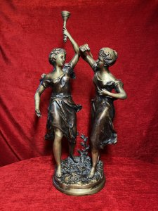 Ernest Rancoulet Bronze Sculpture Of Two Ladies Lighting Torcher Titled 'Olympia' Circa - 1890 Composition - Bronze Origin - France Brief History Of Sculptor Ernest Rancoulet 1870-1915 Prolific French Sculptor Renowned For Figurative Neoclassical Sculpture With Mythological Themes And Allegory. Ernest Rancoulet's Sculptures Are Highly Prized For Their Realism, Grace And Intricate Detailing, Many Of His Sculptures Were Produced As Limited Editions, Some Created In Pairs Usually Of The Same Individual In Different Poses Viewed From Alternate Angles. Rancoulet Resided In The French Salon For Many Years Exhibiting His Works Of Figurines & Portrait Busts, Often Casting Two Varying Copies Of The Same Subject To Be Displayed In Pairs. This Noitoriety And Fine Craftsmanship Of His Work Is Highly Sort After Today. Listing Description. Sculpture Title ; 'Olympia' Wonderful Fine Quality Bronze Figural Sculpture After Ernest Rancoulet, Depicting The Goddess 'Olympia' In Two Poses. The Left Female Gazes To The Right Holding A Torcher In Her Left Hand Above Her Head, The Right Figure Gazes To The Left Holding A Wick In Her Right Hand At Eye Line. Both Figures Styled Gracefully With Hair Set Off The Face, Delicate Facial Features,Wearing The Same Elaborate Gown. Both Figures Set Upon Oval Plinth Of Sprawling Foliage With Tree Sprig. Stunning Original Patina With Vivid Gold Tones. Dimensions In Inches Height 20 1/4" Width 11.5" Base 7" X 7" Provenance Purchased From Parisian Gallery. Now Part Of Lord Hill Museum Private Collection For Further information Please Call 07376618513