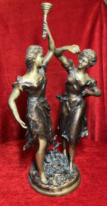 Ernest Rancoulet Bronze Sculpture Of Two Ladies Lighting Torcher Titled 'Olympia' Circa - 1890 Composition - Bronze Origin - France Brief History Of Sculptor Ernest Rancoulet 1870-1915 Prolific French Sculptor Renowned For Figurative Neoclassical Sculpture With Mythological Themes And Allegory. Ernest Rancoulet's Sculptures Are Highly Prized For Their Realism, Grace And Intricate Detailing, Many Of His Sculptures Were Produced As Limited Editions, Some Created In Pairs Usually Of The Same Individual In Different Poses Viewed From Alternate Angles. Rancoulet Resided In The French Salon For Many Years Exhibiting His Works Of Figurines & Portrait Busts, Often Casting Two Varying Copies Of The Same Subject To Be Displayed In Pairs. This Noitoriety And Fine Craftsmanship Of His Work Is Highly Sort After Today. Listing Description. Sculpture Title ; 'Olympia' Wonderful Fine Quality Bronze Figural Sculpture After Ernest Rancoulet, Depicting The Goddess 'Olympia' In Two Poses. The Left Female Gazes To The Right Holding A Torcher In Her Left Hand Above Her Head, The Right Figure Gazes To The Left Holding A Wick In Her Right Hand At Eye Line. Both Figures Styled Gracefully With Hair Set Off The Face, Delicate Facial Features,Wearing The Same Elaborate Gown. Both Figures Set Upon Oval Plinth Of Sprawling Foliage With Tree Sprig. Stunning Original Patina With Vivid Gold Tones. Dimensions In Inches Height 20 1/4" Width 11.5" Base 7" X 7" Provenance Purchased From Parisian Gallery. Now Part Of Lord Hill Museum Private Collection For Further information Please Call 07376618513