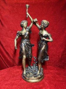 Ernest Rancoulet Bronze Sculpture Of Two Ladies Lighting Torcher Titled 'Olympia' Circa - 1890 Composition - Bronze Origin - France Brief History Of Sculptor Ernest Rancoulet 1870-1915 Prolific French Sculptor Renowned For Figurative Neoclassical Sculpture With Mythological Themes And Allegory. Ernest Rancoulet's Sculptures Are Highly Prized For Their Realism, Grace And Intricate Detailing, Many Of His Sculptures Were Produced As Limited Editions, Some Created In Pairs Usually Of The Same Individual In Different Poses Viewed From Alternate Angles. Rancoulet Resided In The French Salon For Many Years Exhibiting His Works Of Figurines & Portrait Busts, Often Casting Two Varying Copies Of The Same Subject To Be Displayed In Pairs. This Noitoriety And Fine Craftsmanship Of His Work Is Highly Sort After Today. Listing Description. Sculpture Title ; 'Olympia' Wonderful Fine Quality Bronze Figural Sculpture After Ernest Rancoulet, Depicting The Goddess 'Olympia' In Two Poses. The Left Female Gazes To The Right Holding A Torcher In Her Left Hand Above Her Head, The Right Figure Gazes To The Left Holding A Wick In Her Right Hand At Eye Line. Both Figures Styled Gracefully With Hair Set Off The Face, Delicate Facial Features,Wearing The Same Elaborate Gown. Both Figures Set Upon Oval Plinth Of Sprawling Foliage With Tree Sprig. Stunning Original Patina With Vivid Gold Tones. Dimensions In Inches Height 20 1/4" Width 11.5" Base 7" X 7" Provenance Purchased From Parisian Gallery. Now Part Of Lord Hill Museum Private Collection For Further information Please Call 07376618513