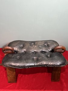 Anglo Indian Camel Stool With Brass Folate Inlays Circa - 1890 Composition - Hard Wood/ Leather Seat Listing Description Anglo Indian Camel Stool With Solid Hard Wood French Polished Frame. Leather Deep Buttoned Saddle Seat Sits Upon Triangular Pillared Legs With Handle Pinnacles For Ease Of Movement. Leg Fronts With Brass Banded Feet And Folate Inlays. Dimensions In Cms Height 42cm X Width 77cm X Depth 38cm X Seat Height 35cm