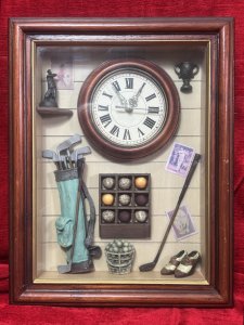 Golfing Enthusiasts Shadow Box/Diorama With Timepiece Circa - Vintage Composition - Wood, Glass, Resin, Mixed Media Listing Description Wonderfully Charming Shadow Box Of Golfing Enthusiasts Cloak Room. Complete With Panelled Wall Decor With Golfing Posters. Central Working (Battery Powered) Timepiece With Mahogany Frame. Corner Shelf With Golfing Statue & Wall Mounted Golfing Trophy. Golf Caddy Bag Complete With Clubs, Golf Ball Display Cabinet And Ball Bucket. As Well As Vintage Leather Style Golfing Shoes. Stunning Piece For Golfing Enthusiast, Man Cave, Library, Study, Hallway Wall Display. Dimensions In Cms Height 41cm X 31.5cm Width X Depth 6cm For Further Information Please Call The Museum Curator Leslie On 07707 488566 Thank-you.