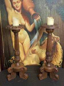 19th Century Large Pair Of Gothic Carved Walnut Tripod Candle Stands. Circa - 1865 Composition- Solid Walnut Condition- Lovely Used A Pair Of Solid Walnut Hand Carved Candles Stands With Shell Top Housing For Large Wax Candle With Decorative Pillar Enriched In Acanthus Leaf Motifs, Standing Upon Solid Tripod Plinth Bases. Beautiful Addition To Gothic Manor. Lovely For Next To An Elaborate Fireplace, Hallway Or Dining Area. Although These Are Being Sold As A Pair They Both Varies Slightly In Design. Please See Images Before Purchase. Provenance Purchased From Country Manor In The Scottish Highlands. Now Part Of Lord Hill Museum Private Collection. Dimensions In Inches Height 29.5” Top Housing Width 9” Tripod Base Width 10”
