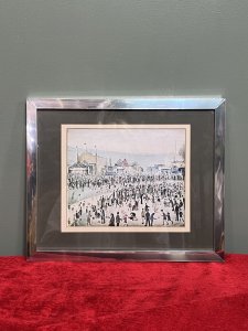 L S Lowry 'The Fairground 1949' Framed Lithograph Print Circa - 1950-1959 Composition - Printed Lithograph On Vellum Brief Artist History Laurence Stephen Lowry 1887-1976 Born into a middle class family and raised in the leafy outskirts of Manchester. Lowrys famous for painting scenes of life in in industrial districts of the North West Of England, where he lived and worked for more than 40 years. He developed a distinctive style of Nieve painting and is best known for his urban landscapes with multiple figures referred to as "Matchstick men". Lowry was never a full time artist. In his early 20's he took a job as a rent collector, and this would be his primary trade for four decades. Although Lowry painted most days after work, Often late into the night, and firmly rejected the term 'Sunday Painter' Remarking 'I'm a Sunday painter that paints every day of the week!" Lowry never adopted a impressionist colour palette and claimed to use five colours vermillion, ivory black, Prussian blue, yellow ochre and flake white. A large collection of Lowrys artworks are on permanent display in 'The Lowry Art Gallery' Salford Quays, named in his honour. Listing Description Original Lithograph of L S Lowry Titled 'The Fairground 1949' Showcasing A Exciting View Of The Fun Fair With Bright Iconic Stalls With Big Top Roofs. A Gathering Of Stalls Of Various Shapes And Sizes Set Amongst A Backdrop Of Blurred Grey Hills With The Shadow Of Factory Buildings. Huge Crowd With Hundreds Of Figures In An Array Of Poses Relevant to The Fairground Celebration. Wonderful Composition By Exceptional British Artist L S LOWRY. A Lithograph Print On Vellum Set Inside Original Glazed Chrome Frame. Dimensions In Inches Height 10.5" X Width 12 3/4" For Further information Please Call 07707488566 Thank-you