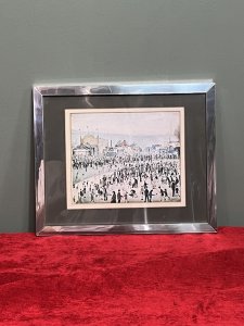 L S Lowry 'The Fairground 1949' Framed Lithograph Print Circa - 1950-1959 Composition - Printed Lithograph On Vellum Brief Artist History Laurence Stephen Lowry 1887-1976 Born into a middle class family and raised in the leafy outskirts of Manchester. Lowrys famous for painting scenes of life in in industrial districts of the North West Of England, where he lived and worked for more than 40 years. He developed a distinctive style of Nieve painting and is best known for his urban landscapes with multiple figures referred to as "Matchstick men". Lowry was never a full time artist. In his early 20's he took a job as a rent collector, and this would be his primary trade for four decades. Although Lowry painted most days after work, Often late into the night, and firmly rejected the term 'Sunday Painter' Remarking 'I'm a Sunday painter that paints every day of the week!" Lowry never adopted a impressionist colour palette and claimed to use five colours vermillion, ivory black, Prussian blue, yellow ochre and flake white. A large collection of Lowrys artworks are on permanent display in 'The Lowry Art Gallery' Salford Quays, named in his honour. Listing Description Original Lithograph of L S Lowry Titled 'The Fairground 1949' Showcasing A Exciting View Of The Fun Fair With Bright Iconic Stalls With Big Top Roofs. A Gathering Of Stalls Of Various Shapes And Sizes Set Amongst A Backdrop Of Blurred Grey Hills With The Shadow Of Factory Buildings. Huge Crowd With Hundreds Of Figures In An Array Of Poses Relevant to The Fairground Celebration. Wonderful Composition By Exceptional British Artist L S LOWRY. A Lithograph Print On Vellum Set Inside Original Glazed Chrome Frame. Dimensions In Inches Height 10.5" X Width 12 3/4" For Further information Please Call 07707488566 Thank-you