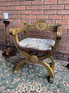 Spanish Carved Oak Cross Frame Hall Chair In Charles II Manor Circa 1890. Circa - 1890 Composition- Solid Oak Exceptional Heavily Carved Hall Chair With Coat Of Arms Back Rest, Sweeping Arm Rests With Arched X Frame Support Stretchers. Beautiful Webbed Seat In Wool Work Tapestry Depicting King & Queen In Floral Landscape With Braided Edge. Stunning Original Patina. A Solid Chair With Exceptional Comfort And Style. Collector Piece. Provenance Purchased In Madrid Collector Sale, Now Part Of Lord Hill Museum Private Collection. Dimensions In Inches Back Height 29” Arm Rest Height 24” Seat Height 17” Back Rest Width 24.7” Depth 18.5”
